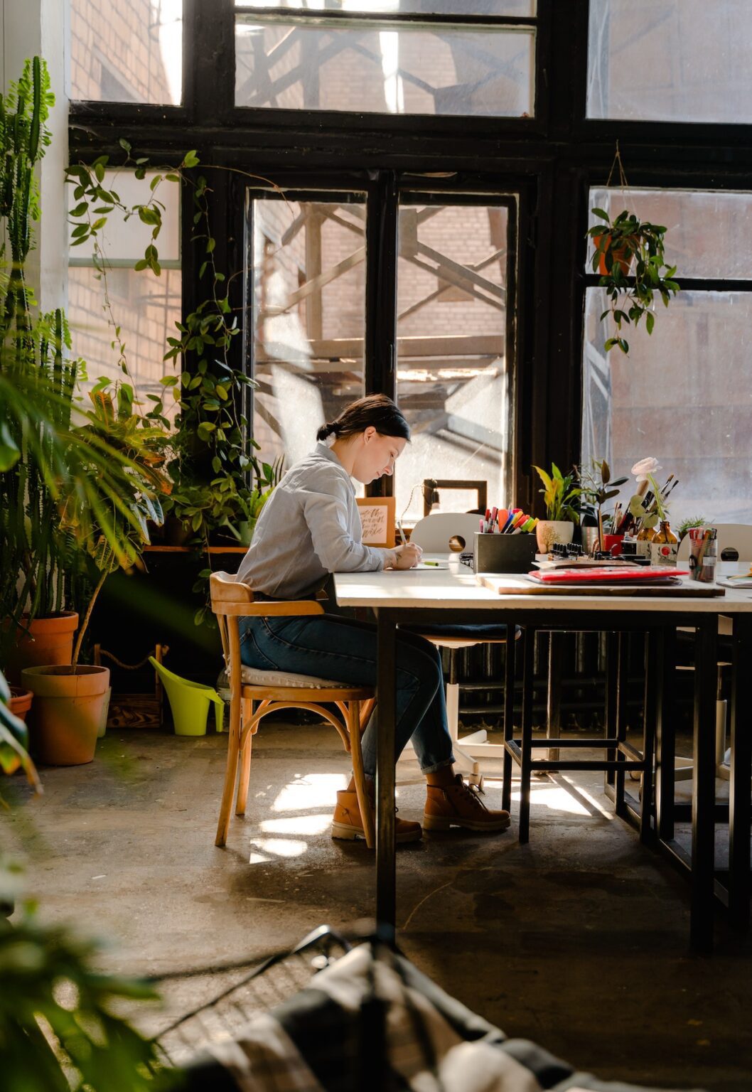 Woman sitting at a table writing on a piece of paper