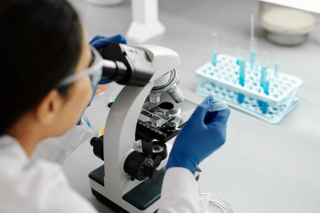 Researcher examining samples through a microscope