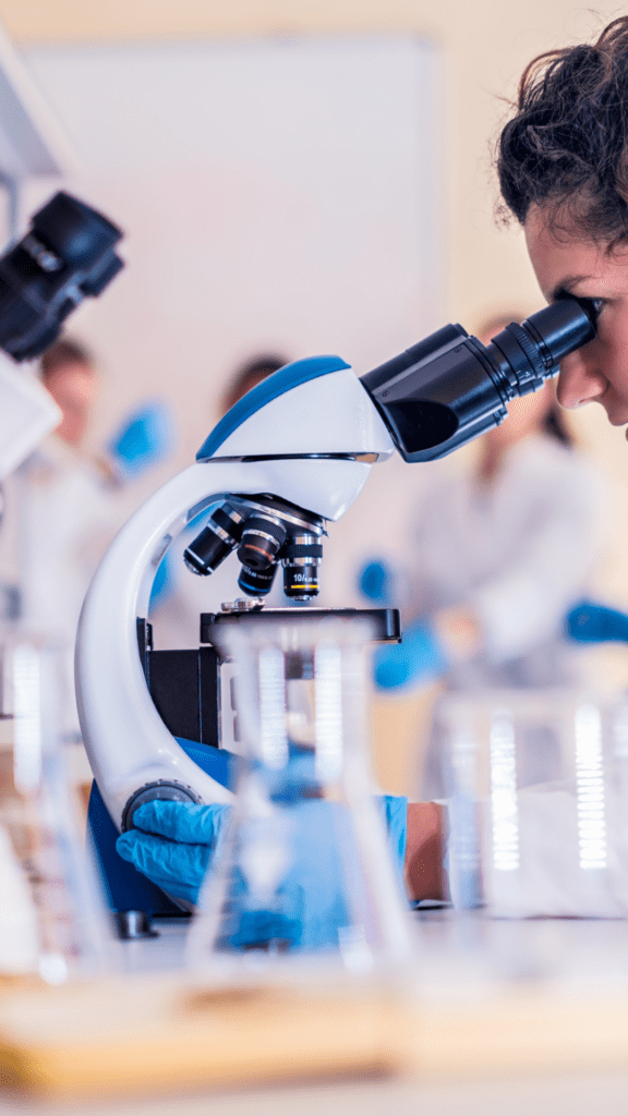 A scientist looking at a sample under a microscope